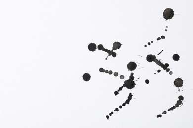 Photo of Blots of black ink on white background, flat lay. Space for text