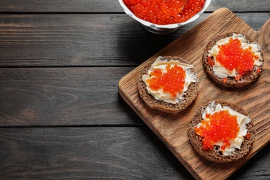 Flat lay composition with red caviar on wooden background