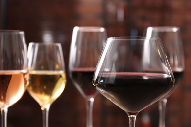 Photo of Tasty red wine in glass against blurred background, space for text