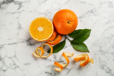 Photo of Orange fruits with peels on white marble table, flat lay