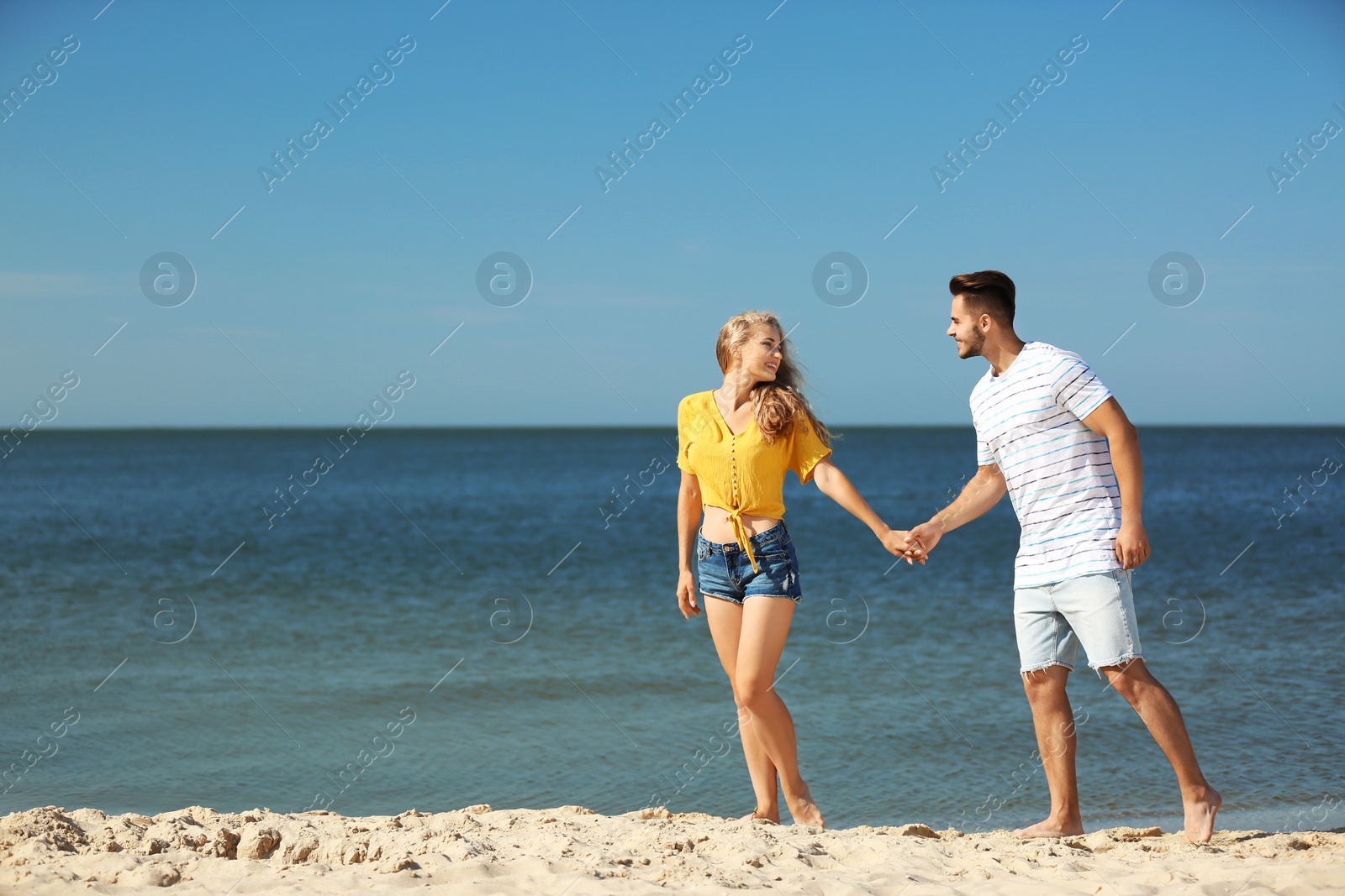 Photo of Happy young couple at beach on sunny day