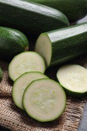 Photo of Whole and cut ripe zucchinis on table, closeup