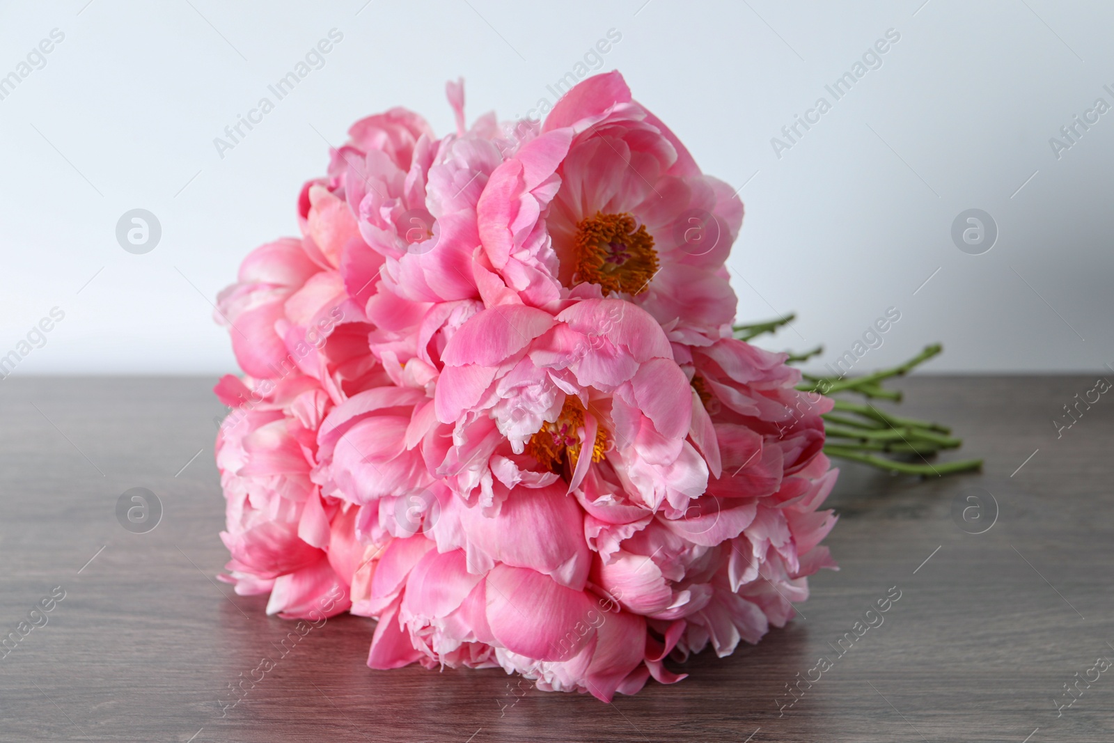 Photo of Bunch of beautiful pink peonies on wooden table