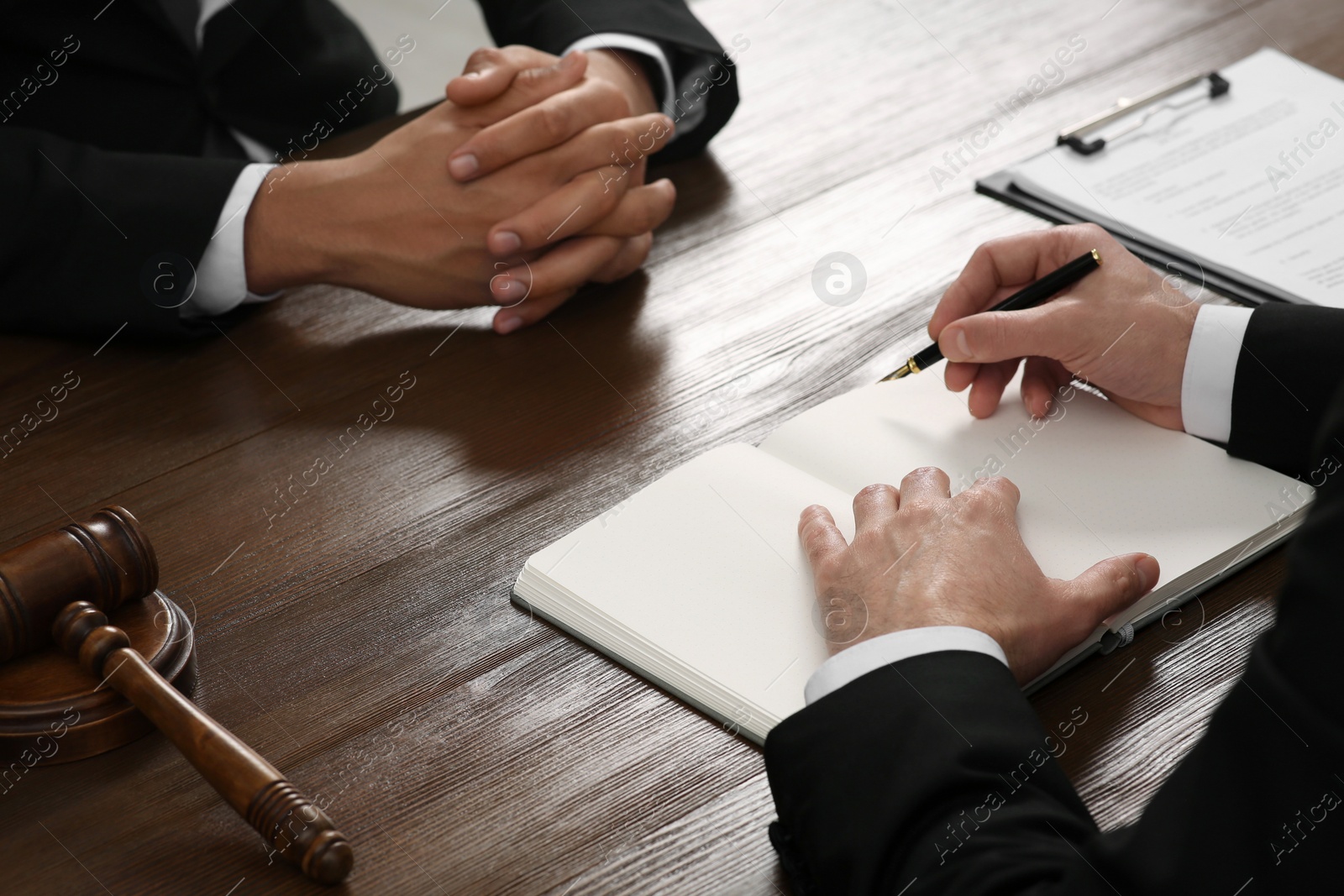 Photo of Law and justice. Lawyers working with documents at wooden table, closeup