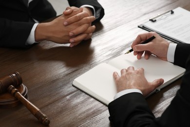 Law and justice. Lawyers working with documents at wooden table, closeup