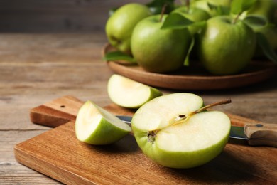 Photo of Cut fresh green apple on wooden table, closeup
