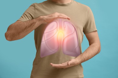 Man holding hands near chest with illustration of lungs on turquoise background, closeup