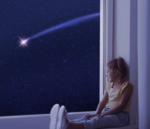 Image of Cute little girl sitting on windowsill and looking at shooting star in beautiful night sky