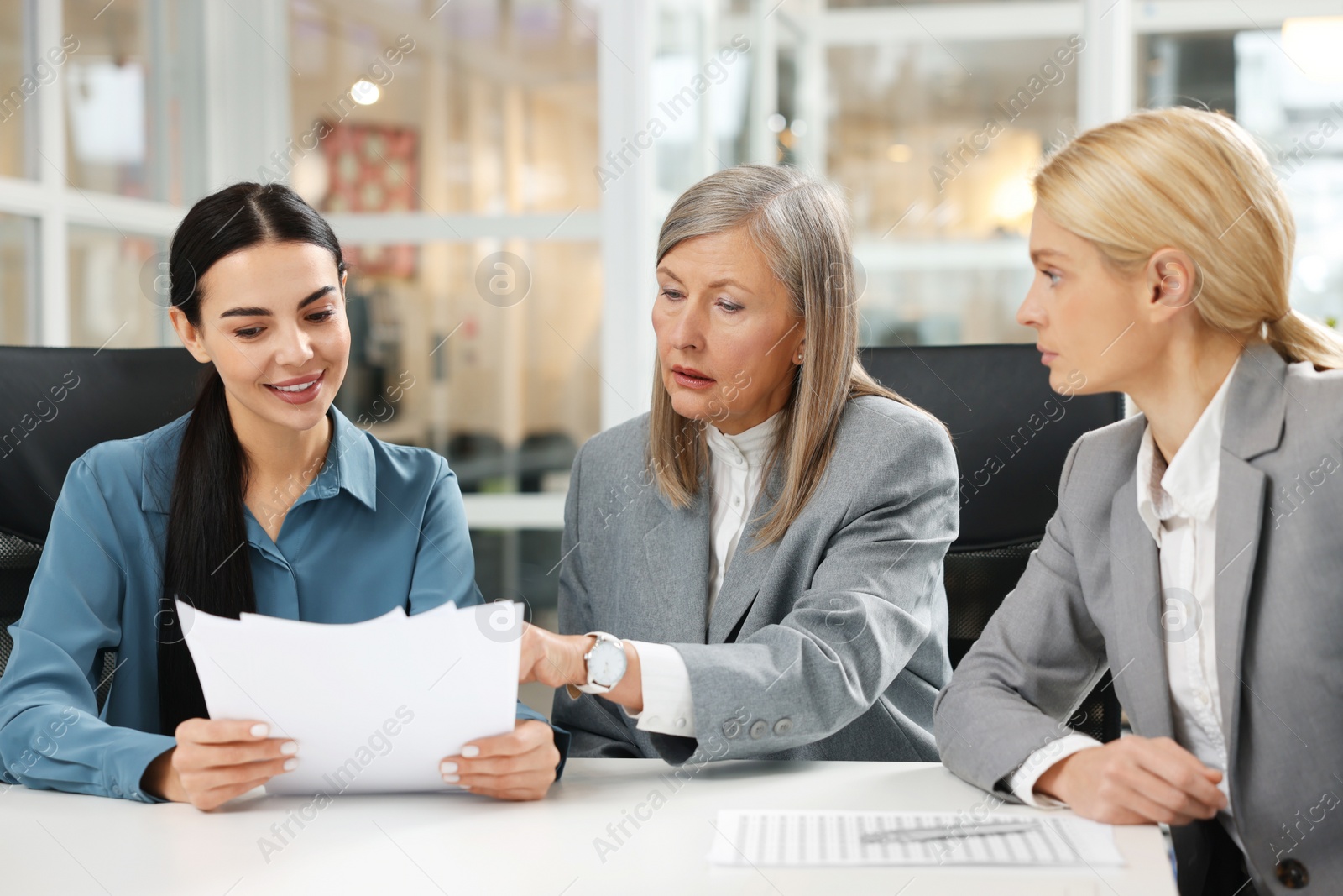 Photo of Lawyers working together with documents at table in office