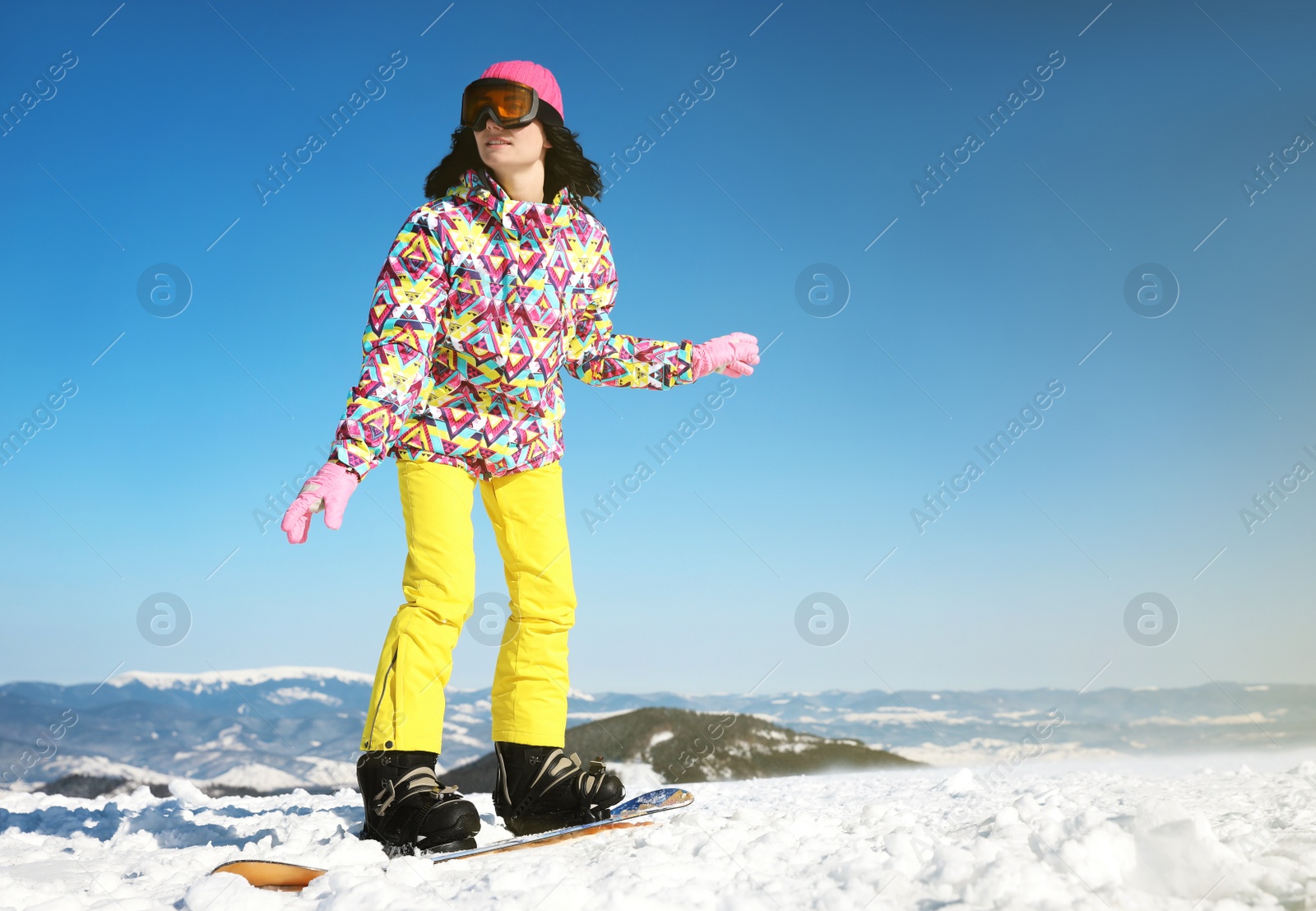 Photo of Young woman snowboarding on hill, space for text. Winter vacation