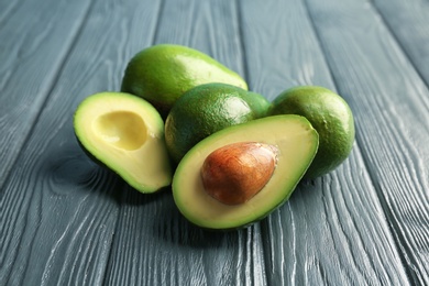 Photo of Tasty ripe green avocados on wooden background