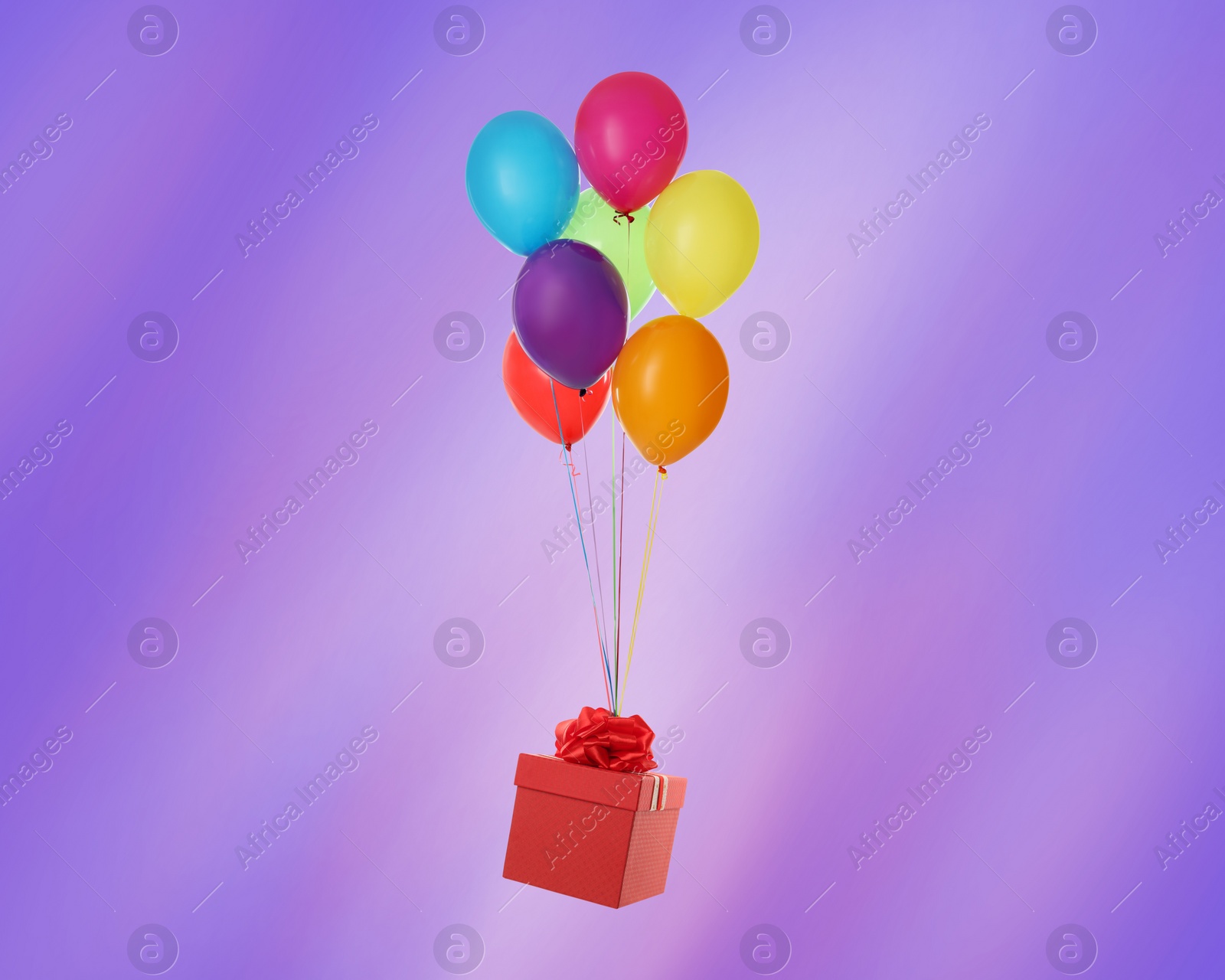 Image of Many balloons tied to red gift box on bright background
