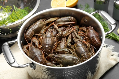 Fresh raw crayfishes in pot on table, closeup