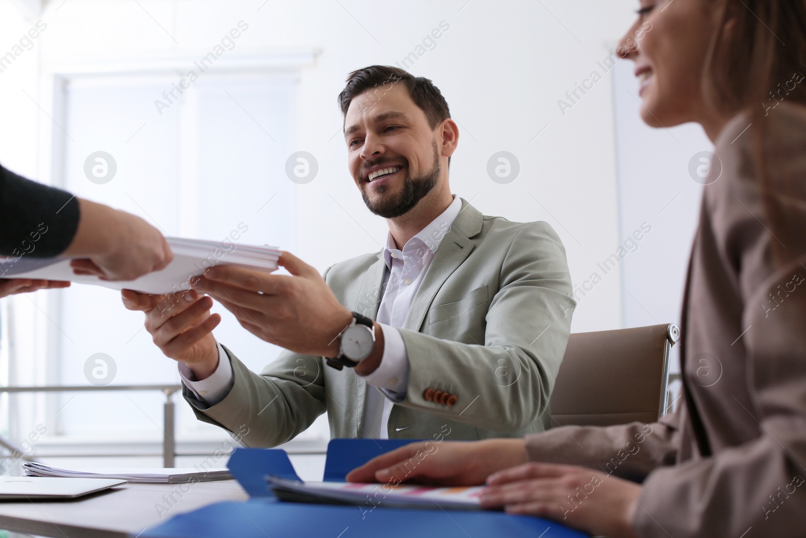 Photo of Office employees working with documents at table indoors