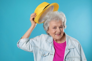 Portrait of mature woman in hipster outfit on color background