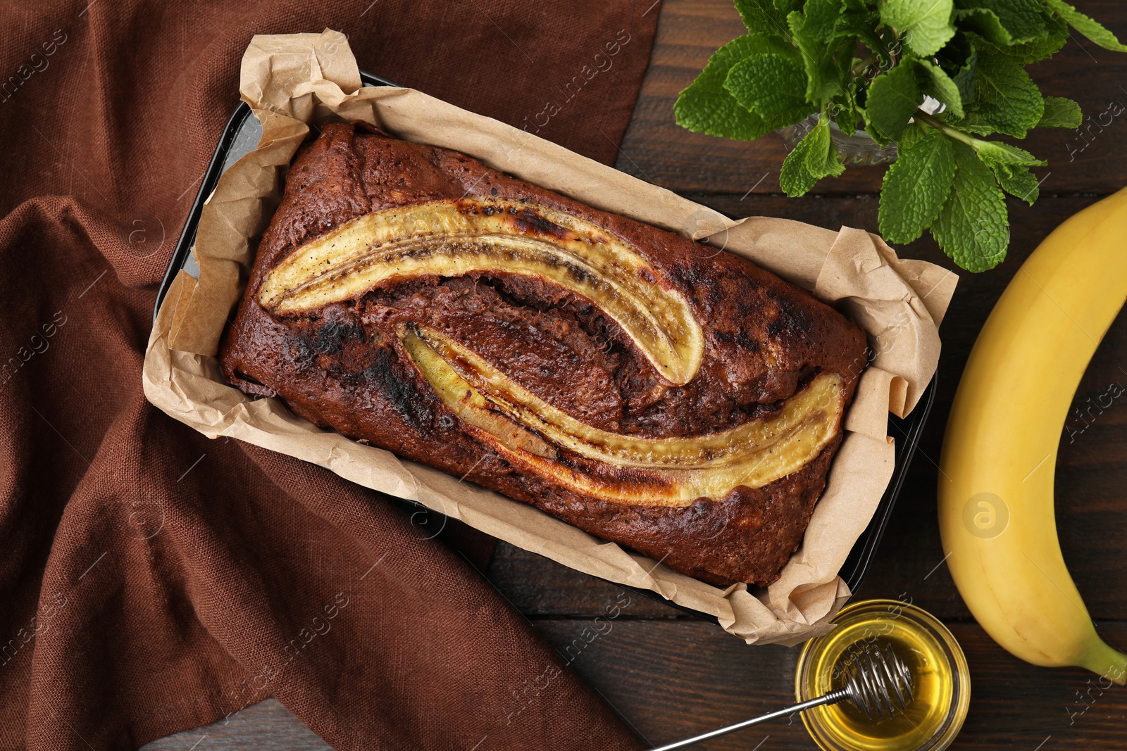 Photo of Delicious banana bread and ingredients on wooden table, flat lay