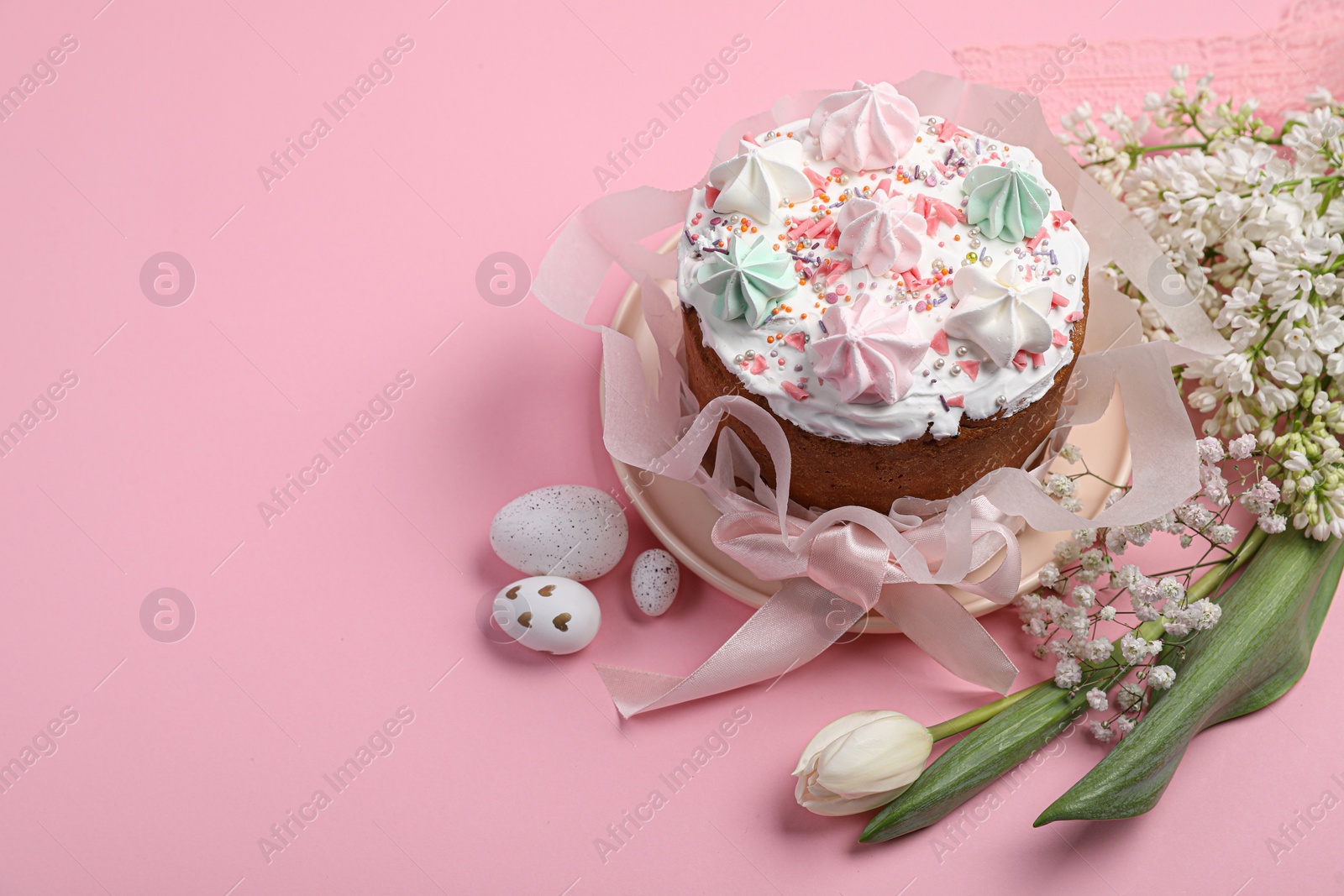 Photo of Traditional Easter cake with meringues and painted eggs on pink background, space for text