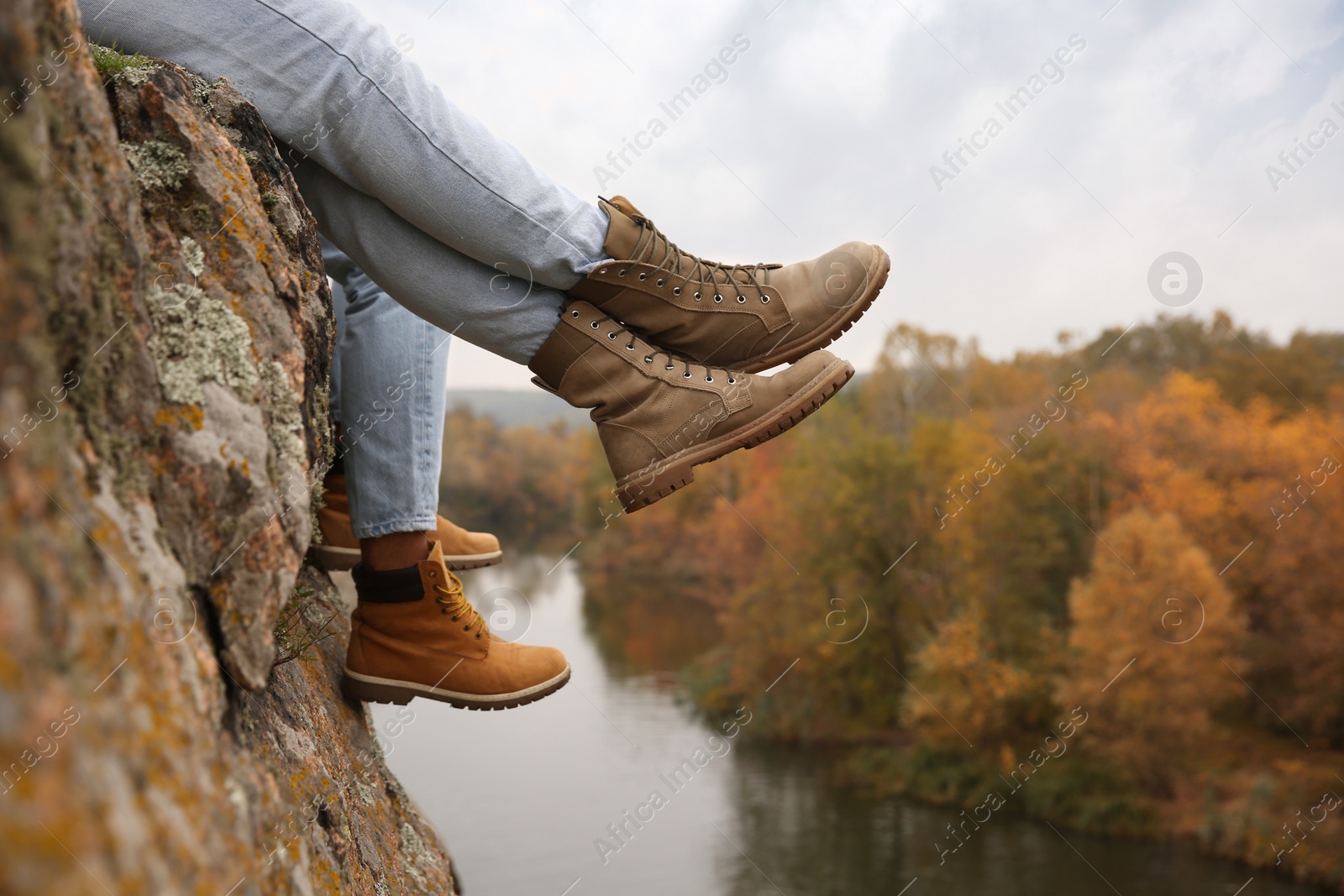 Photo of Couple wearing stylish hiking boots on steep cliff, closeup