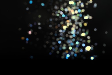 Photo of Blurred view of colorful festive lights on black background. Bokeh effect