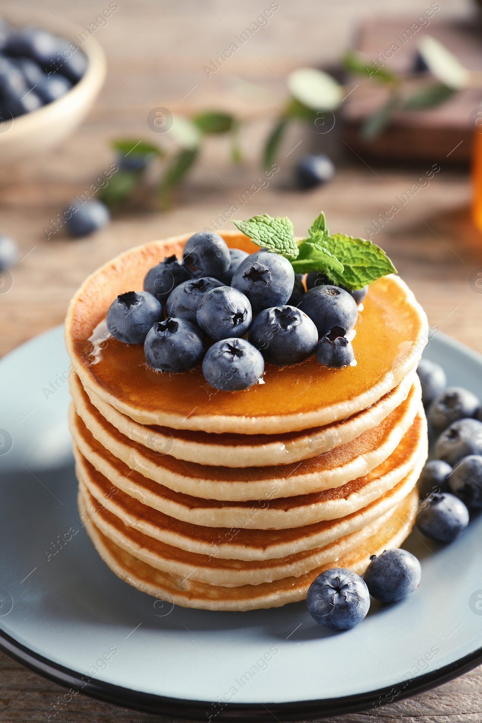 Photo of Plate with pancakes and berries on wooden table