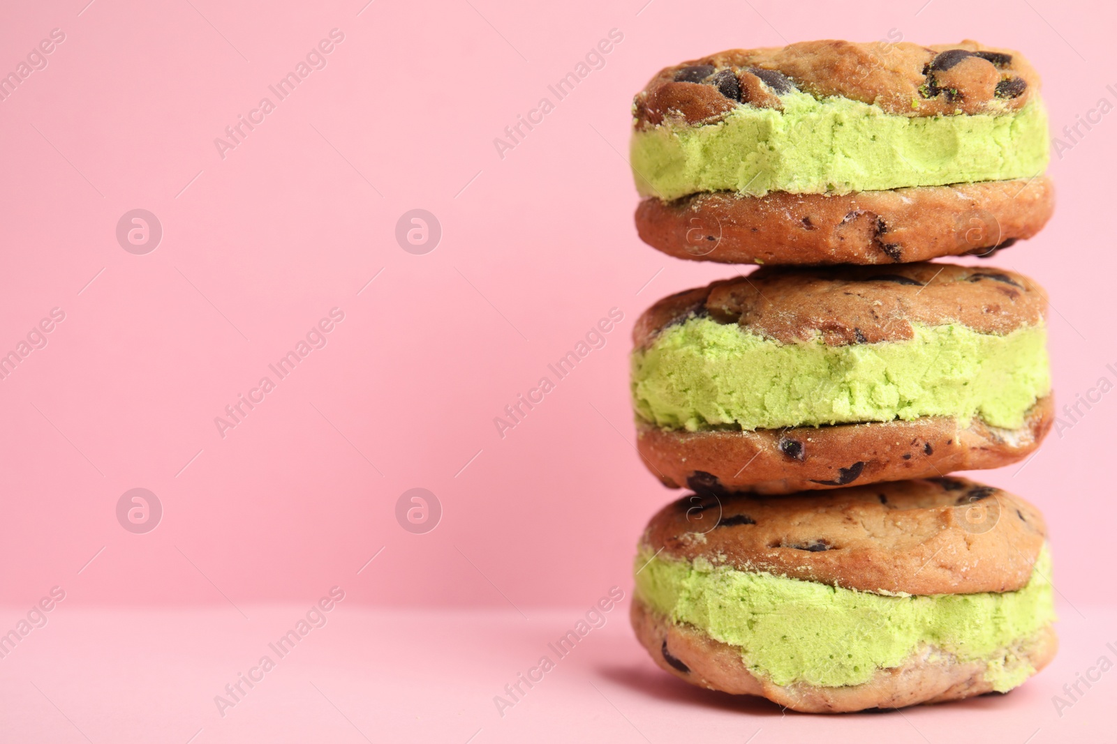 Photo of Sweet delicious ice cream cookie sandwiches on color background, space for text