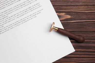 One stamp tool and document on wooden table, top view