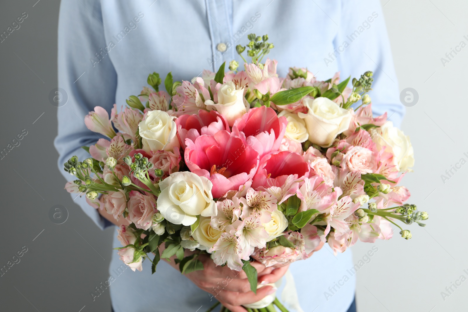 Photo of Woman with beautiful bouquet of fresh flowers on light background, closeup
