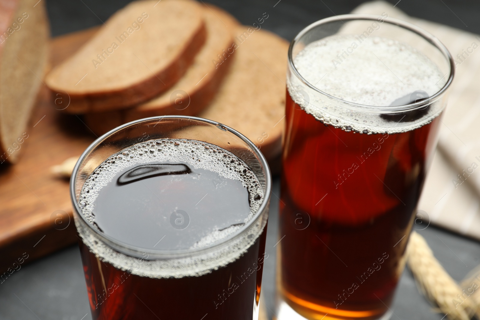 Photo of Glasses of delicious kvass on black table, closeup