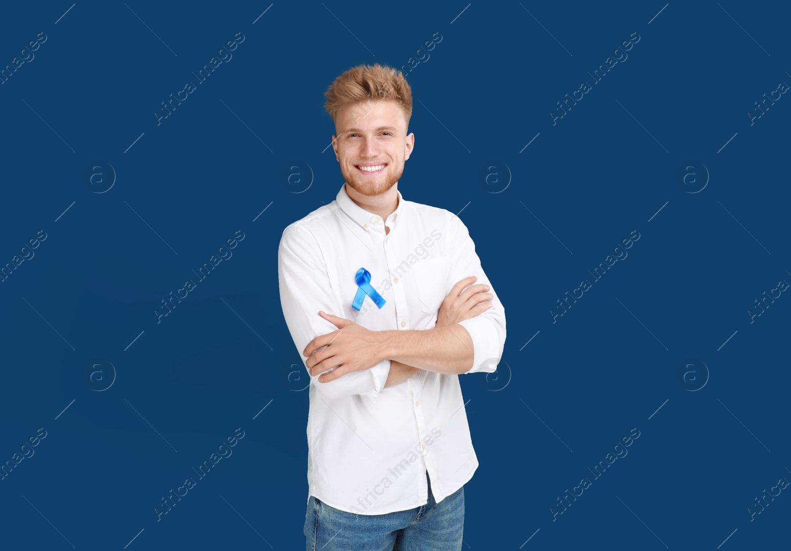 Photo of Young man with ribbon on blue background. Urology cancer awareness