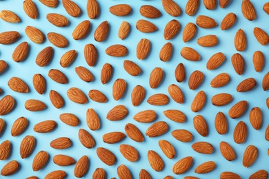 Composition with organic almond nuts on color background, top view