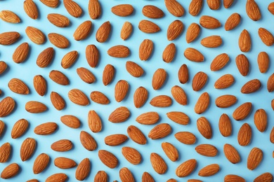 Photo of Composition with organic almond nuts on color background, top view