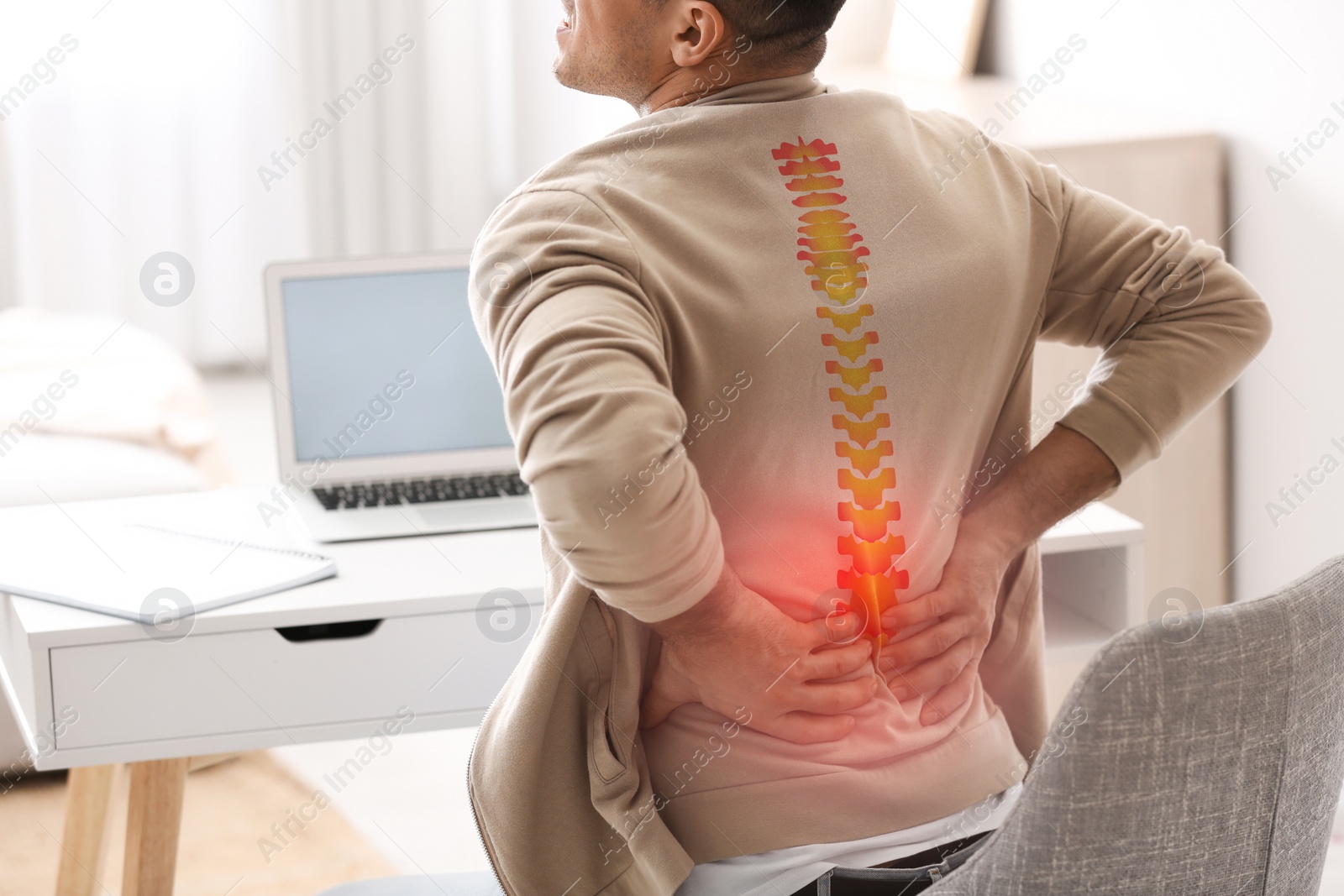Image of Man suffering from back pain at table, closeup. Bad posture problem