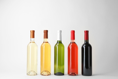 Photo of Bottles of expensive wines on light background