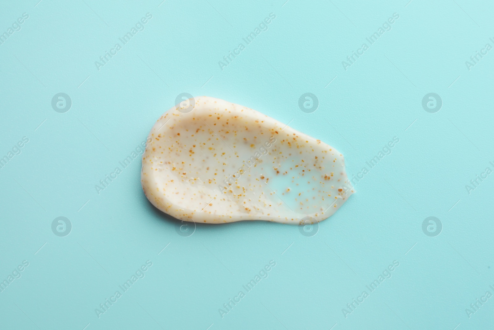 Photo of Sample of face scrub on light blue background, top view