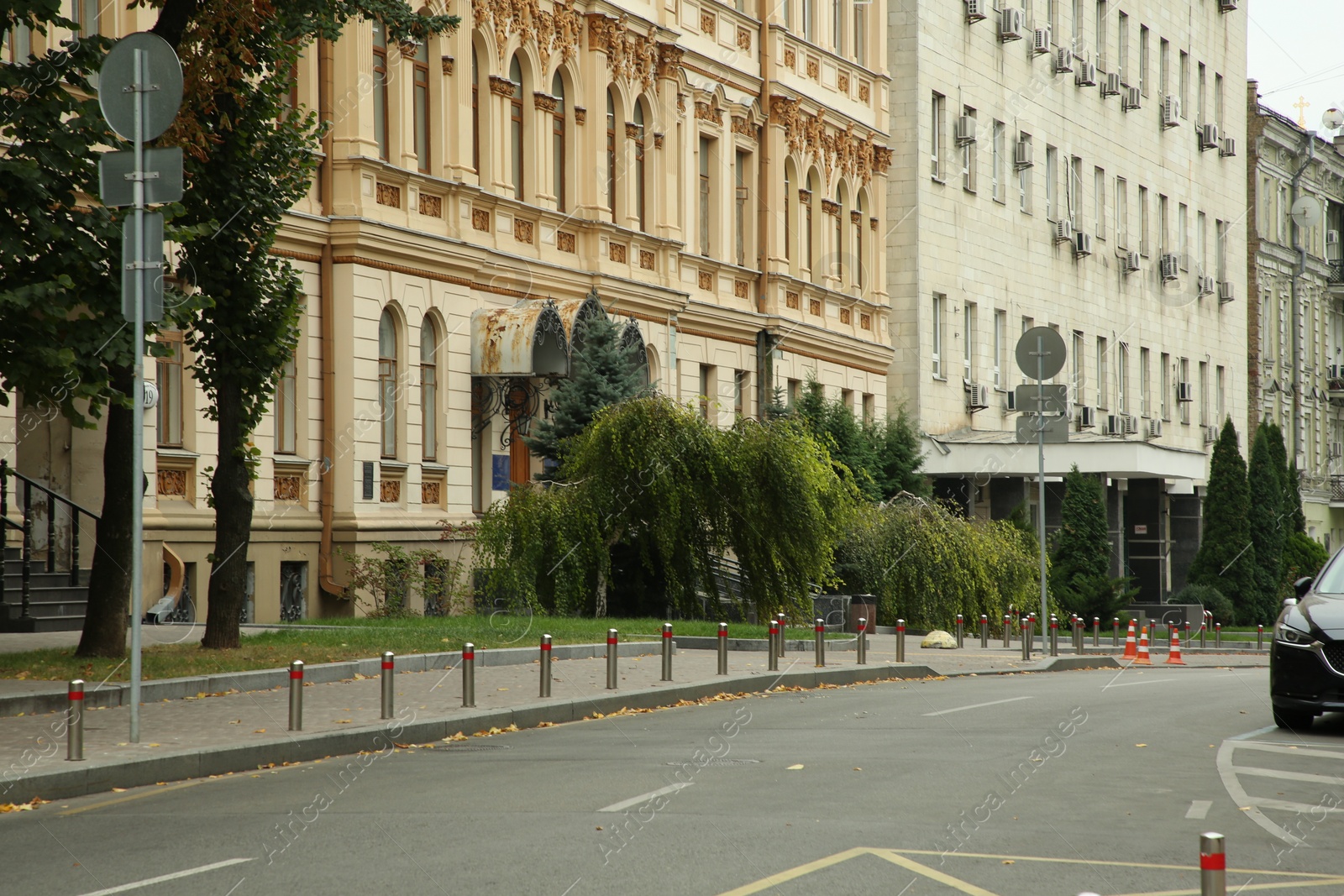 Photo of Picturesque view of quiet street with beautiful buildings, road and trees