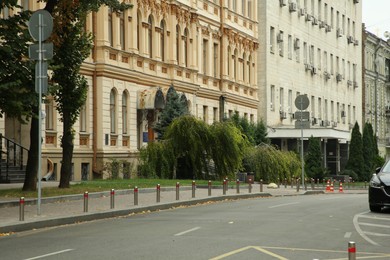 Photo of Picturesque view of quiet street with beautiful buildings, road and trees