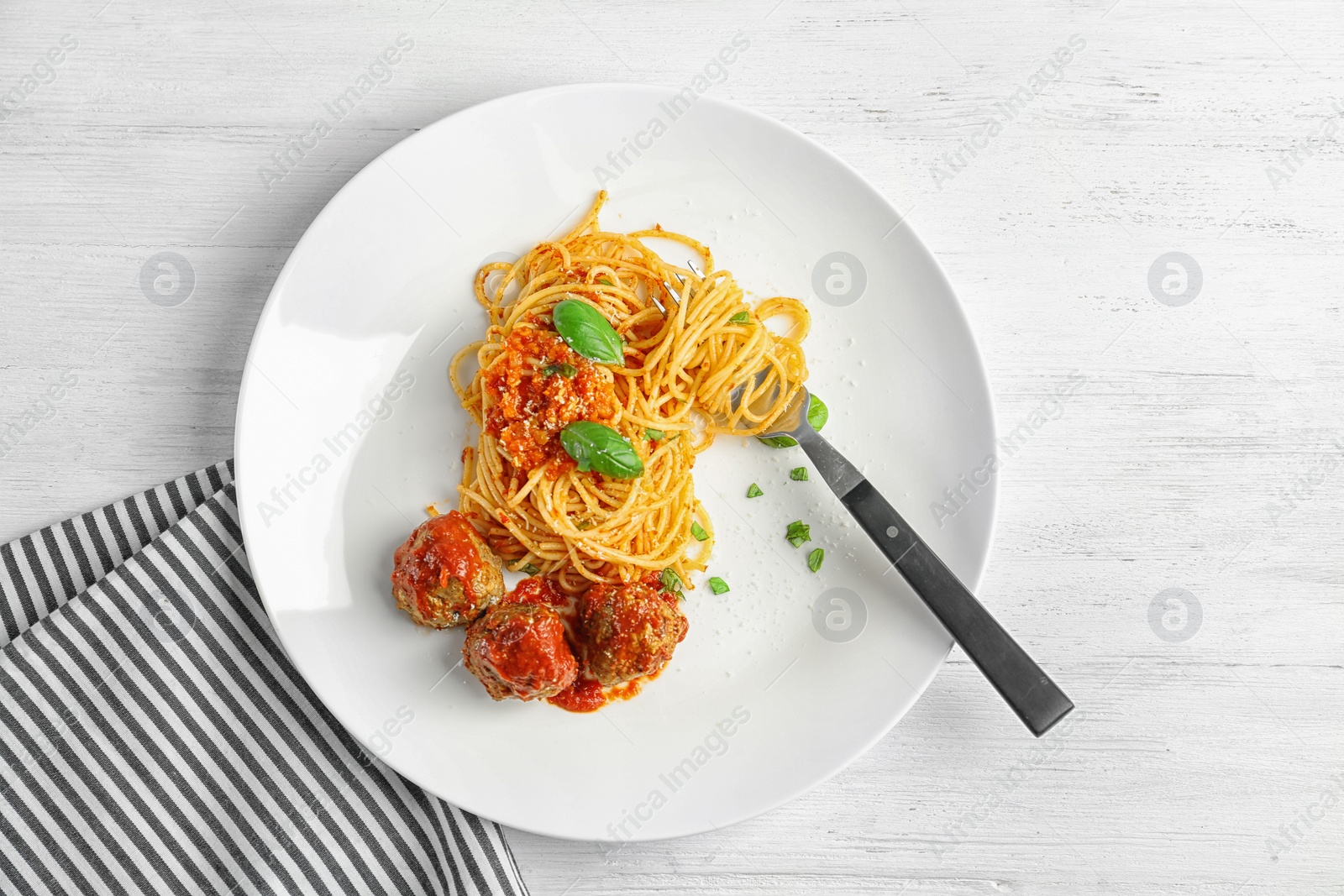 Photo of Delicious pasta with meatballs and tomato sauce on wooden background