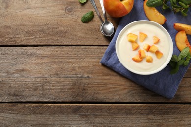 Photo of Delicious yogurt with fresh peach on wooden table, flat lay. Space for text