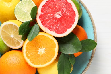 Photo of Different cut and whole citrus fruits on white table, top view