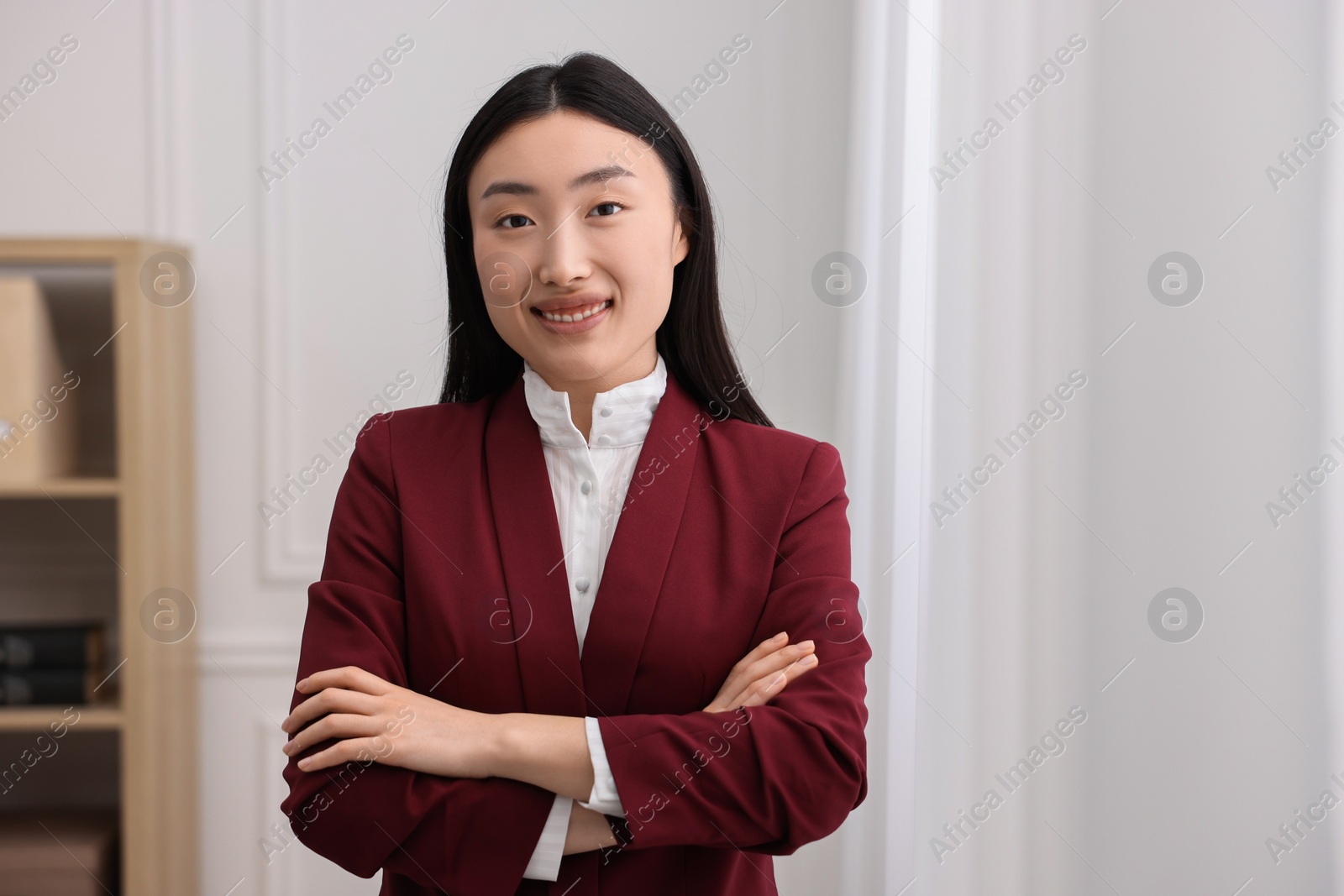 Photo of Portrait of smiling notary with crossed arms in office