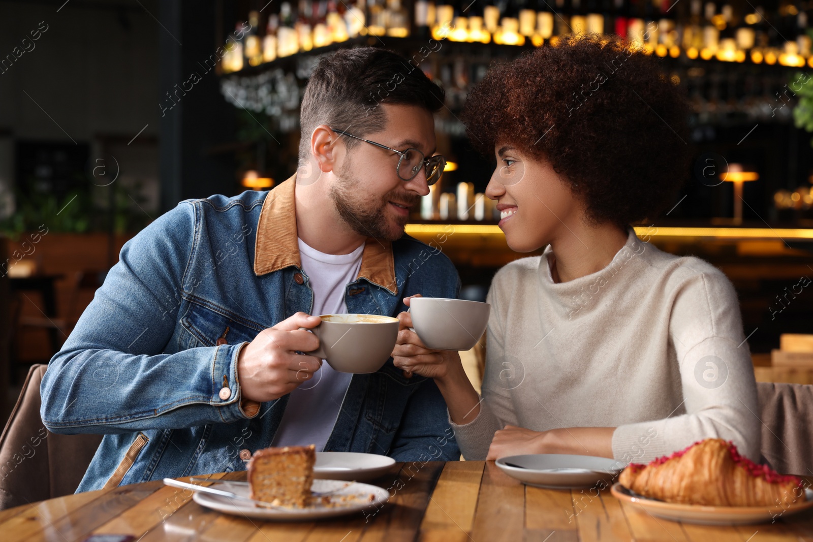 Photo of International relationships. Lovely couple having romantic date in cafe