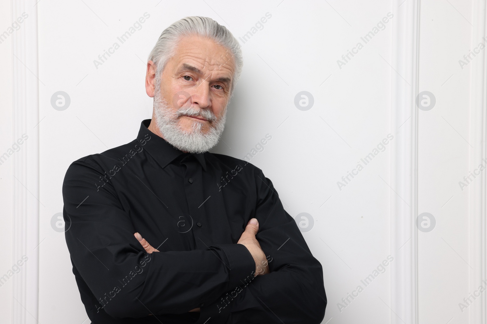 Photo of Portrait of handsome senior man near white wall. Space for text