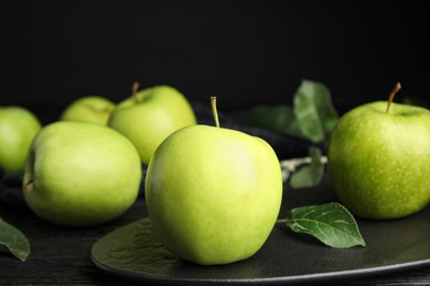 Photo of Fresh ripe green apples on black wooden table, space for text