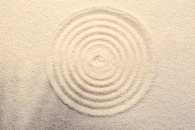 Photo of Zen rock garden. Circle pattern on beige sand, top view