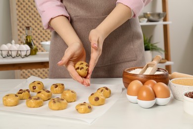 Photo of Woman preparing chocolate chip cookies at white table in kitchen, closeup