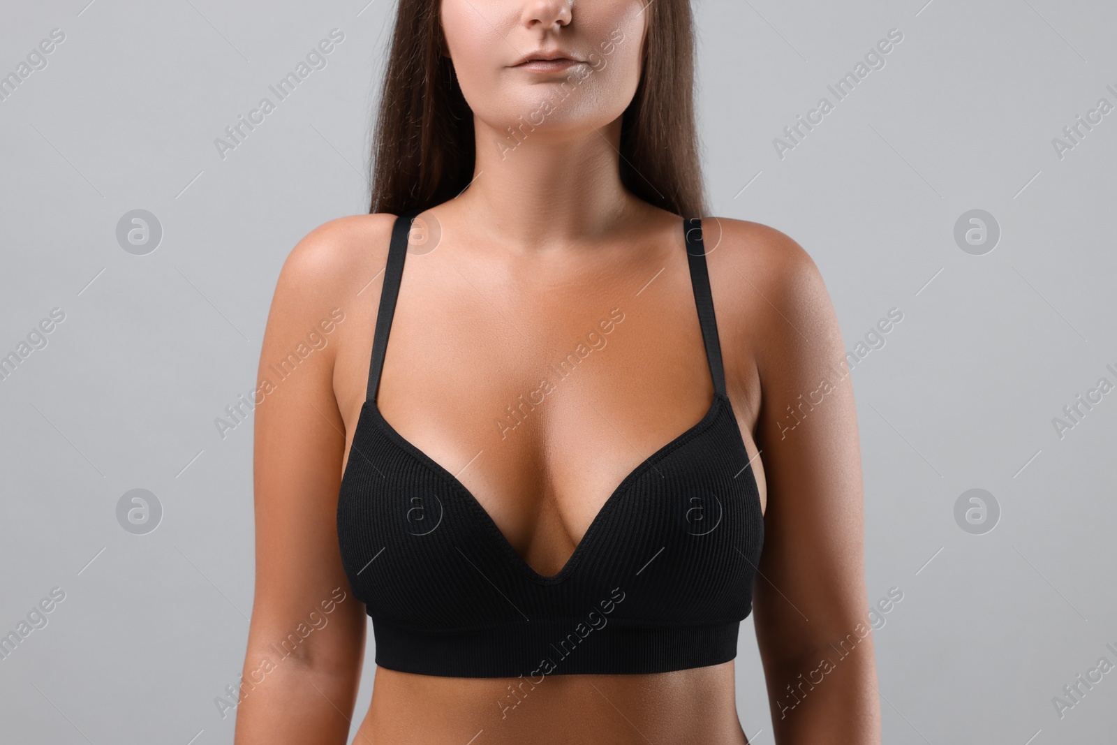 Photo of Woman with beautiful breast on light grey background, closeup