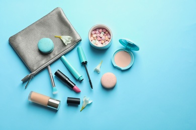 Makeup products with cosmetic bag on color background