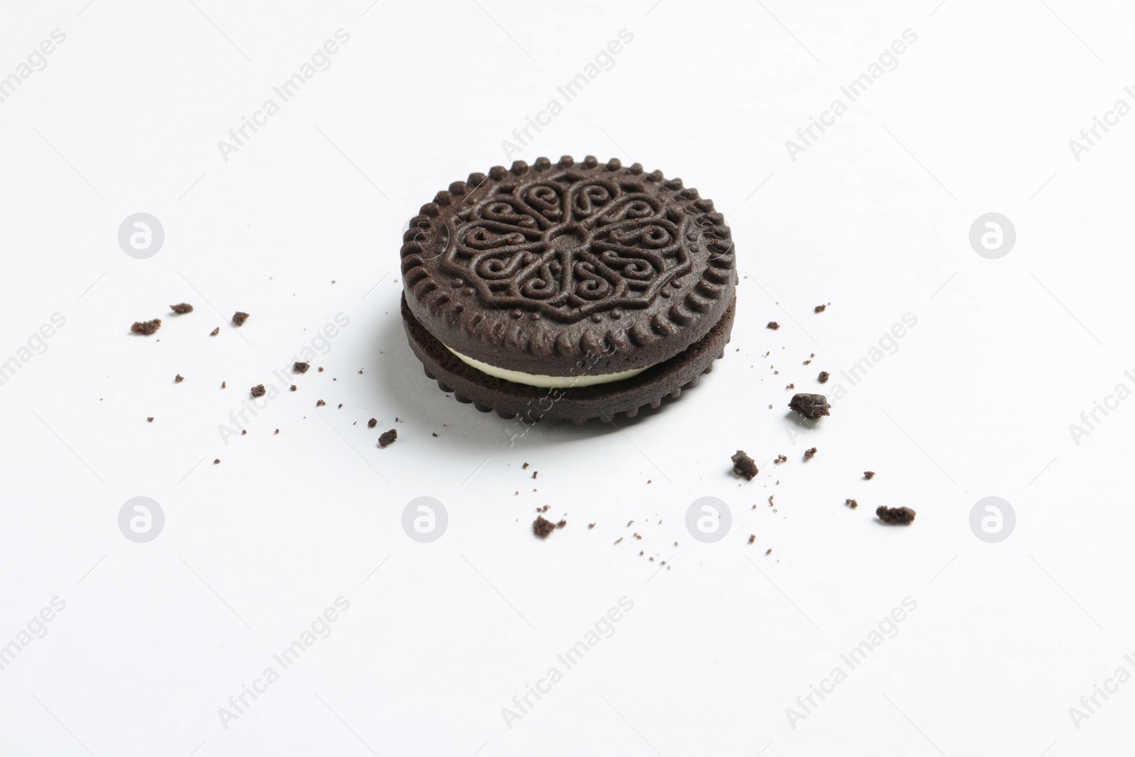 Photo of Tasty chocolate cookie and crumbs on white background