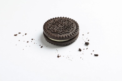 Photo of Tasty chocolate cookie and crumbs on white background
