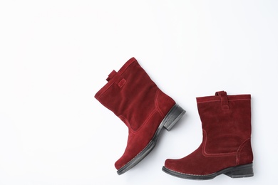 Stylish red female boots on white background, top view